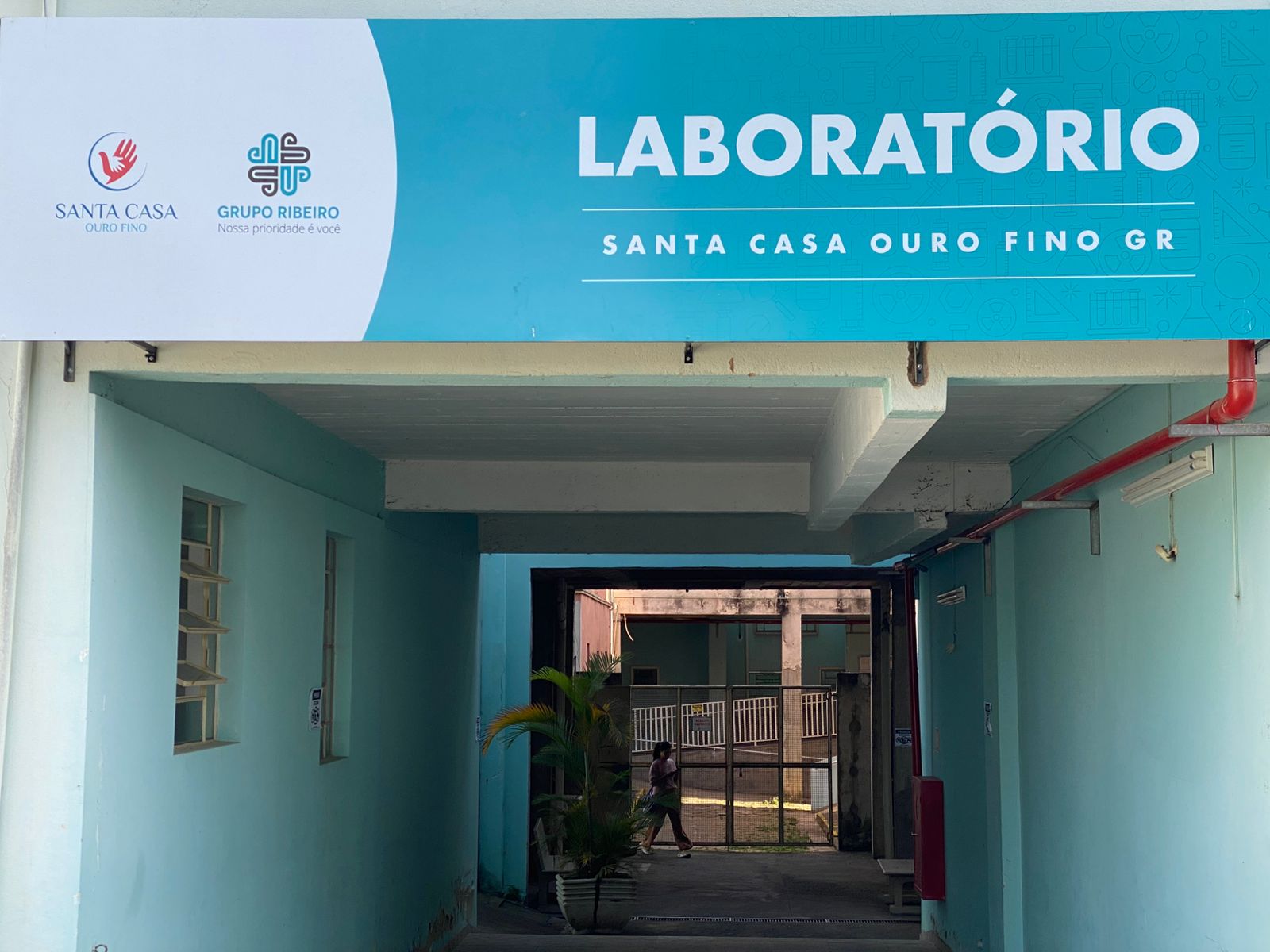 placa em verde e branco, na fachada do prédio